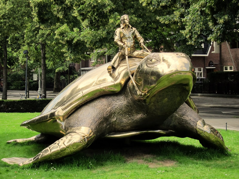 Памятник- человек сидящий на черепахе в Амстердаме. Фото