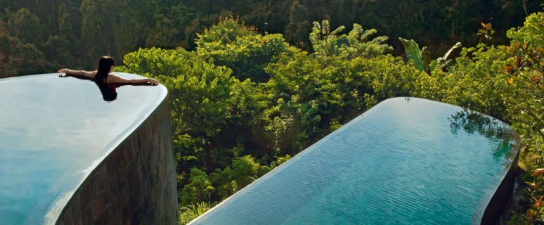 Indonesia, Bali, Gianyar, Buahan Payangan, Ubud Hanging Gardens hotel group Orient-Express, one young woman back outstretched arms, infinity pool overlooking the jungle at sunrise